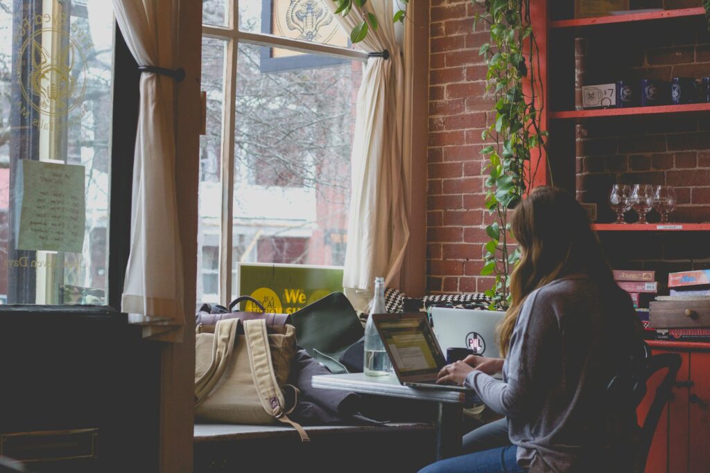 Woman working remotely in a cozy cafe on a laptop – representing Passive Income Ideas for Europeans in 2025 and the freedom of online income.